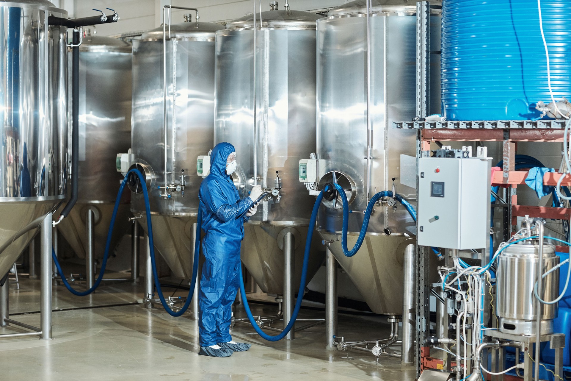 Worker in protective gear operating storage tanks