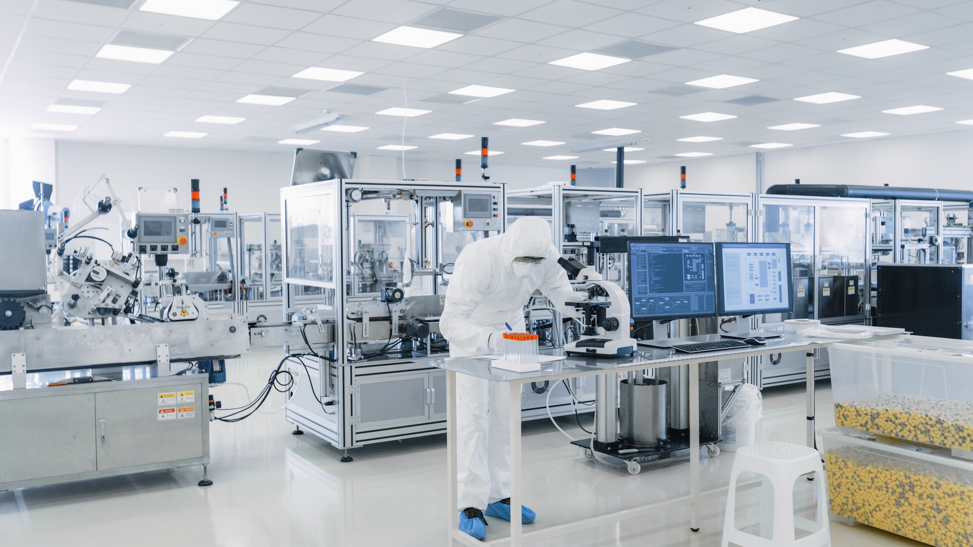 Shot of Sterile Pharmaceutical Manufacturing Laboratory where Scientists in Protective Coverall's Do Research, Quality Control and Work on the Discovery of new Medicine.