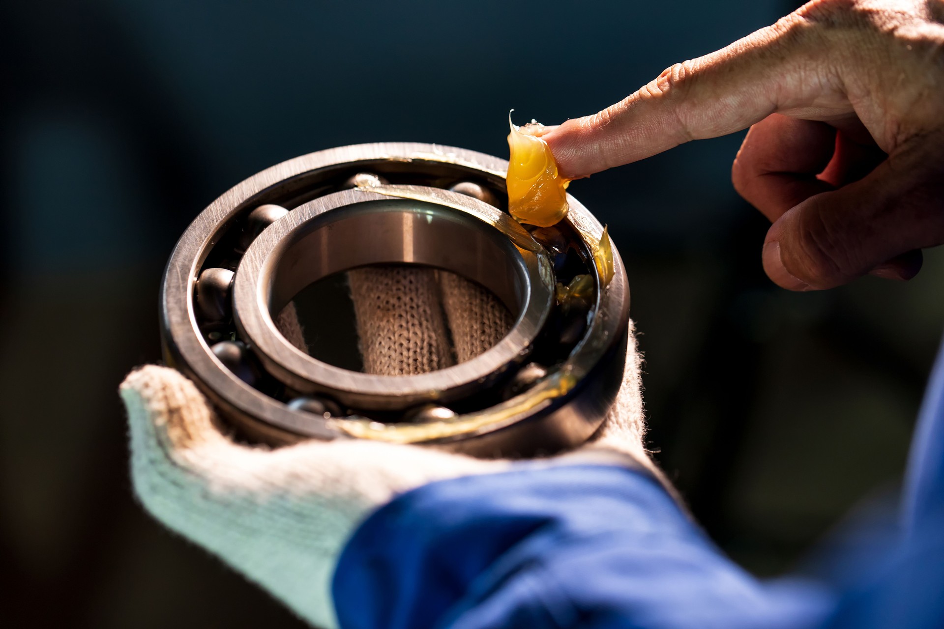 Close up of lubricant grease in hand Mechanic for putting into ball bearing in the industrial factory, Mechanic Industrial Concept